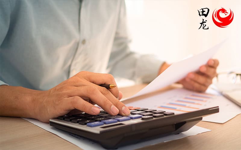 Accountant using a calculator and reviewing financial documents